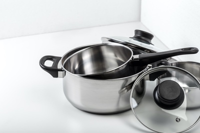 stainless steel pots saucers lids on white background